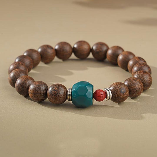 Golden Satinwood Harmony Bracelet - A modern spiritual life mala inspired by Tibetan Buddhism jewelry culture. This genuine handcrafted piece combines rare satinwood, protective red cinnabar, and bright glass, made in accordance with traditional Tibetan proportions. Representing the harmony of nature and spirit in Tibetan Buddhism jewelry culture this hand is both a powerful meditation aid and a beautiful piece of natural wooden jewelry. Handcrafted by artisans.