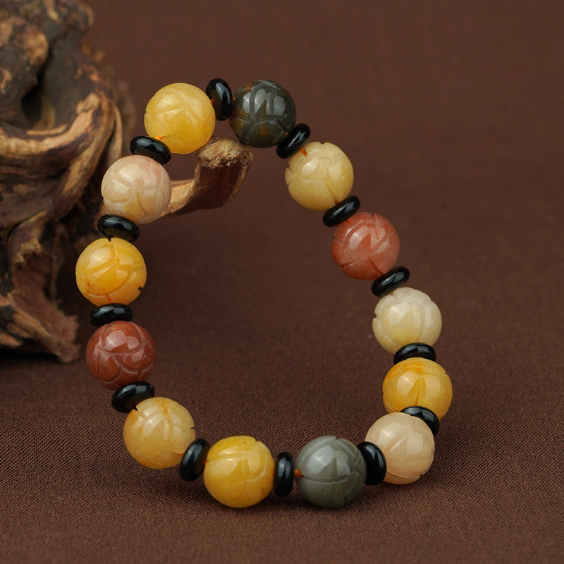 Handmade Tibetan Buddhist bracelet featuring golden silk jade round beads and protective obsidian accents. This sacred jewelry art embodies traditional Tibetan craftsmanship for spiritual practice and energy balance.