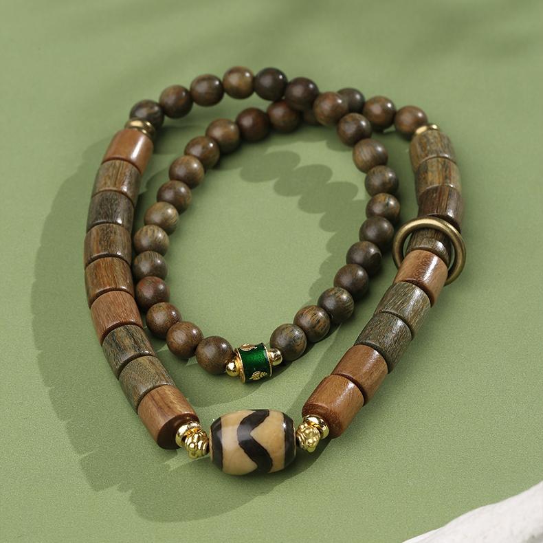Handmade Tibetan Buddhist multi-strand bracelet featuring green sandalwood and agate tooth beads with copper accents. This sacred jewelry art embodies traditional Tibetan craftsmanship for spiritual practice.