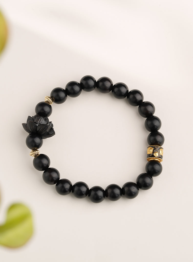 Handcrafted ebony lotus and cinnabar bead bracelet, showcasing unique jewelry artistry while perfectly blending the powers of spirit and aesthetics.