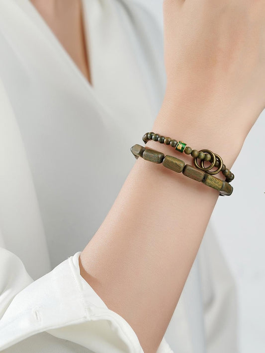 Wind Murmur multi-circle green sandalwood bracelet demonstrating Tibetan Buddhist jewelry art. Expertly handcrafted with copper accents for spiritual awareness and meditation.