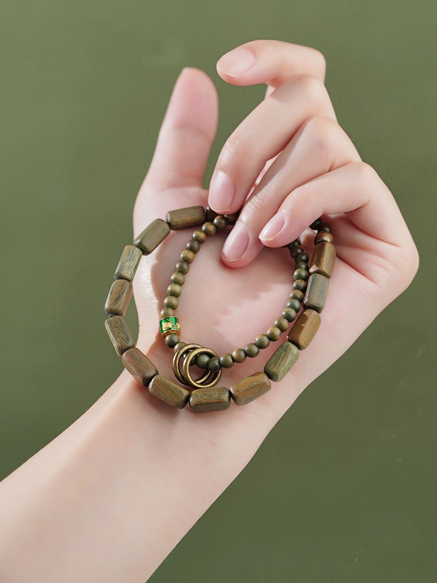 Whispering Zephyr sandalwood and copper bracelet representing Tibetan Buddhist jewelry culture. Each hand-made piece combines green sandalwood's natural beauty with traditional metalwork.