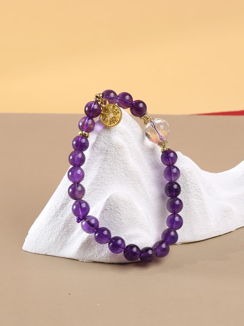 Amethyst and quartz bead bracelet handcrafted with Tibetan Buddhist symbolism, offering calming energy and spiritual connection for meditation and daily wear.