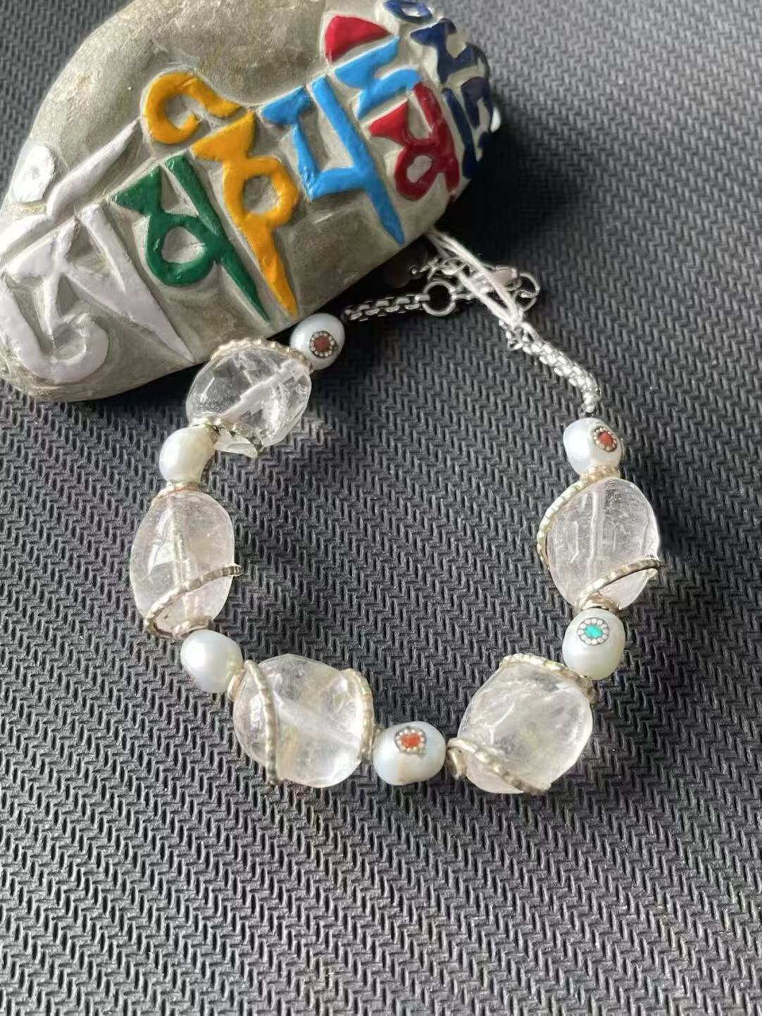 Alt Text: Purely handcrafted white crystal bracelet with intricate Tibetan Buddhist art. Designed to bring spiritual harmony and protection to the wearer.