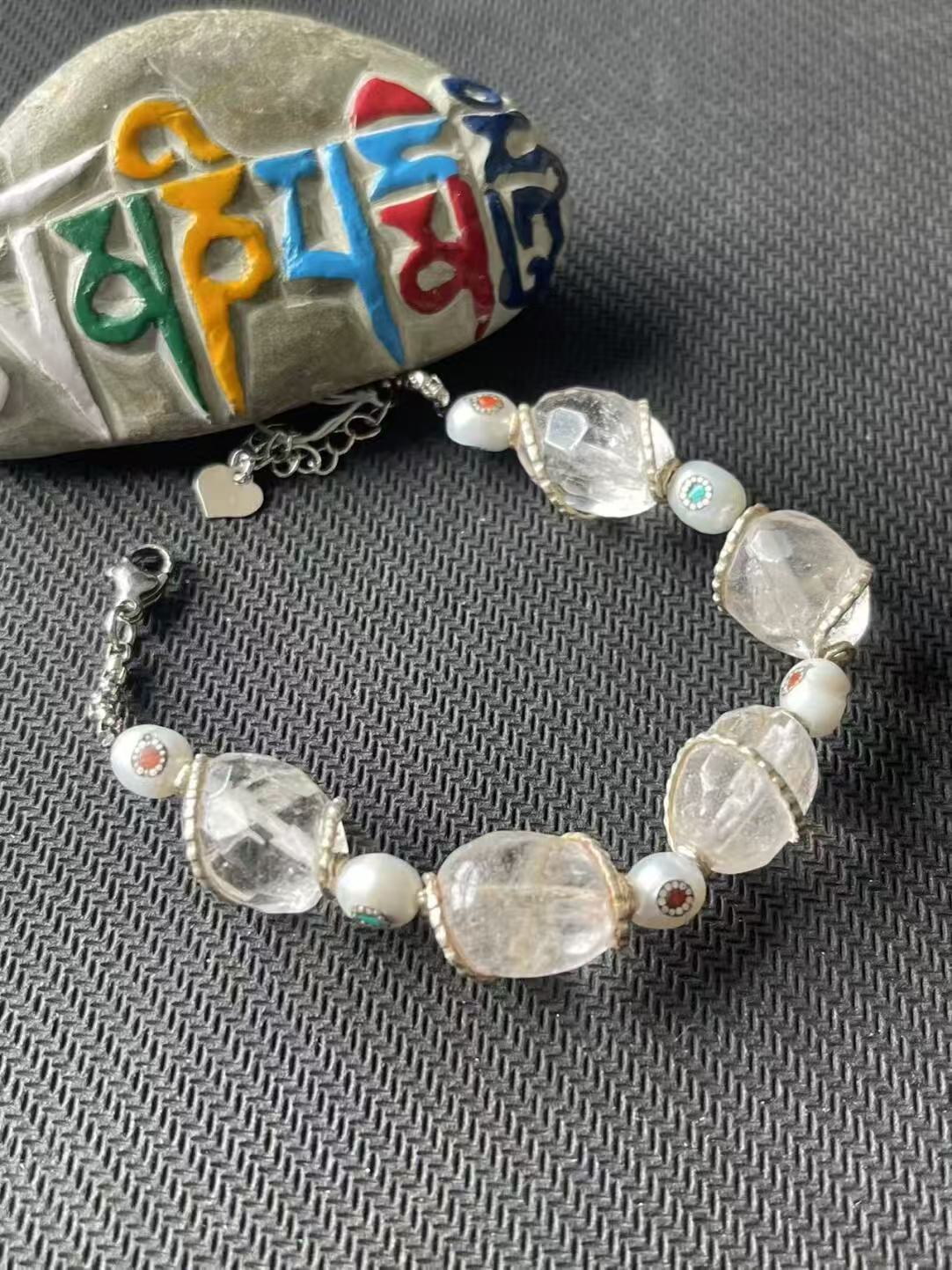 Alt Text: Minimalist white crystal bracelet with multi-treasure design. Crafted in the Tibetan Buddhist tradition to enhance prosperity and spiritual well-being.