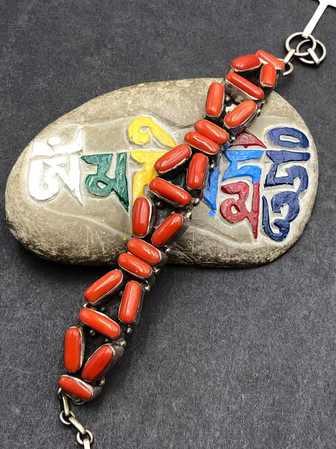 Red plastic bracelet with hand-painted elements, representing Tibetan Buddhist art, symbolizing vitality and spiritual growth, a bold yet meaningful addition to any wardrobe.