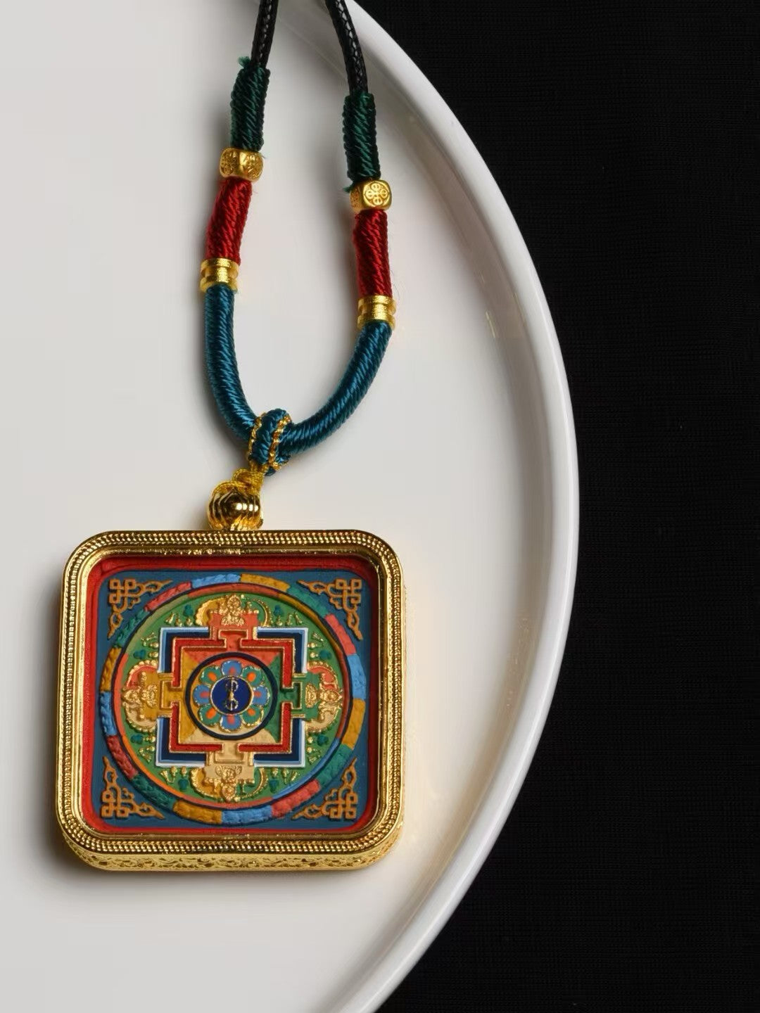 Handmade mandala thangka pendant representing Tibetan Buddhist jewelry culture and traditional spiritual jewelry art.
