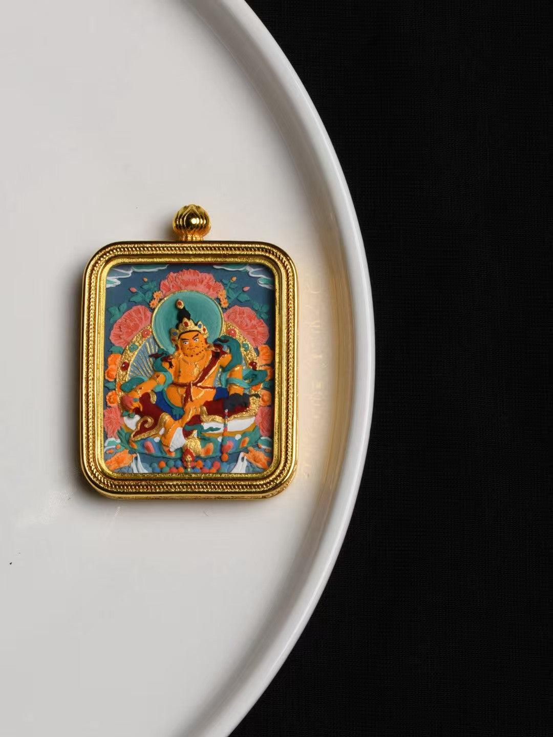 Traditional Yellow Jambhala thangka pendant representing Tibetan Buddhist jewelry culture and prosperity blessings.