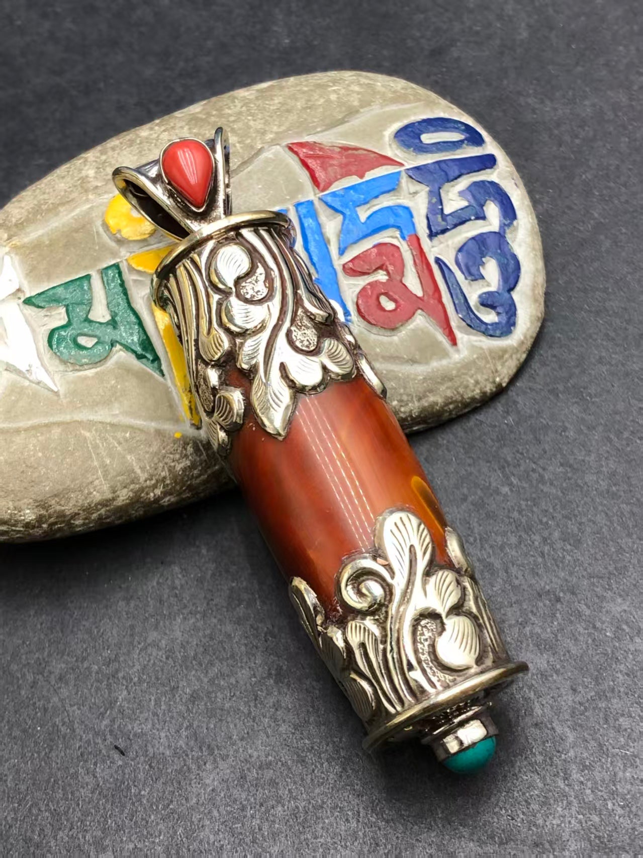 Traditional red agate pendant with Tibetan Buddhist motifs. A beautiful piece of jewelry that represents inner peace, balance, and protection.