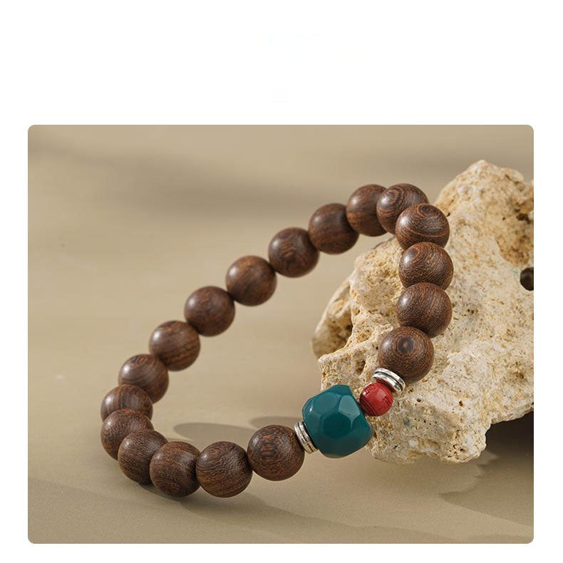 Sunrise Forest Nanmu Beads - Tibetan Buddhist Jewelry Culture Collection, featuring natural cinnabar and glass inlay. Handcrafted by art, these golden threads of nanmu wood beads naturally shimmer, complemented by protective red cinnabar and wisdom-embodied glass adornments. This handmade bracelet emb the essence of Tibetan Buddhist jewelry culture through its organic materials and sacred geometry. A wearable spiritual art treasure designed for conscious collectors.