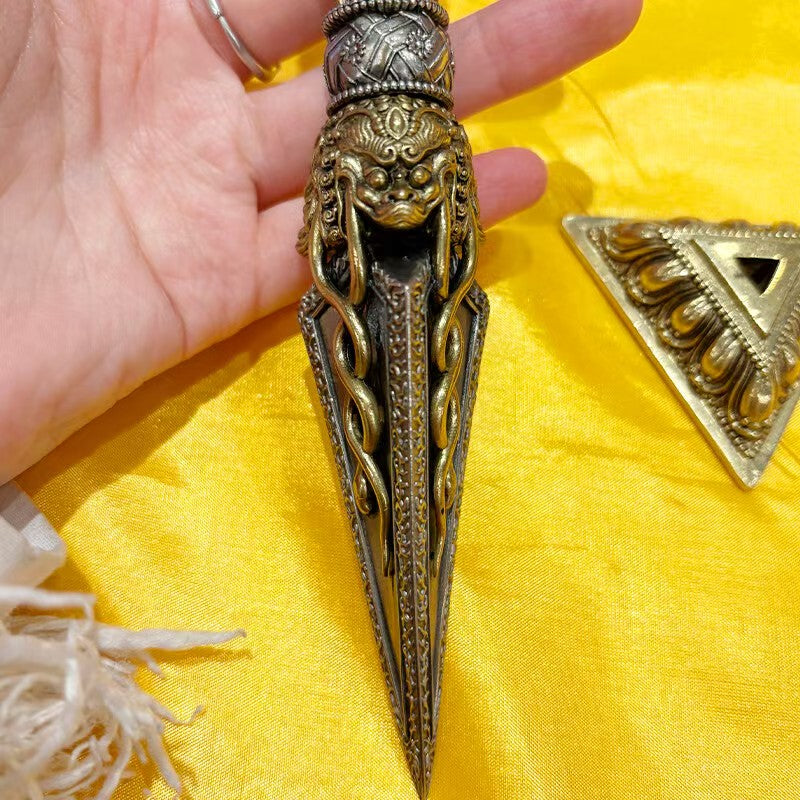 Handcrafted brass Phurba Vajra dagger with base, rooted in Tibetan Buddhist ritual implements culture and Buddhist ritual implements art, symbolizing protection and the subjugation of negative energies.