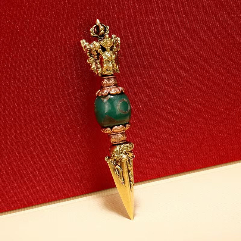 This brass three-sided Phurba integrates ancient Tibetan Dzi bead designs, showcasing the art and significance of Tibetan Buddhist ritual implements. Handcrafted with care, it serves as a powerful protector and spiritual tool, ideal for devotional use.