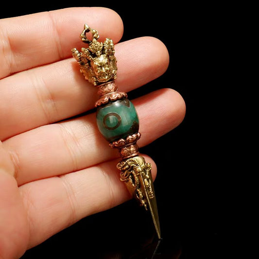 This three-sided brass Phurba, featuring Tibetan Dzi beads, reflects the spiritual power of Tibetan Buddhism. Handcrafted with intricate details, it serves as a powerful ritual tool, ideal for personal worship, home decor, or as a spiritual artifact