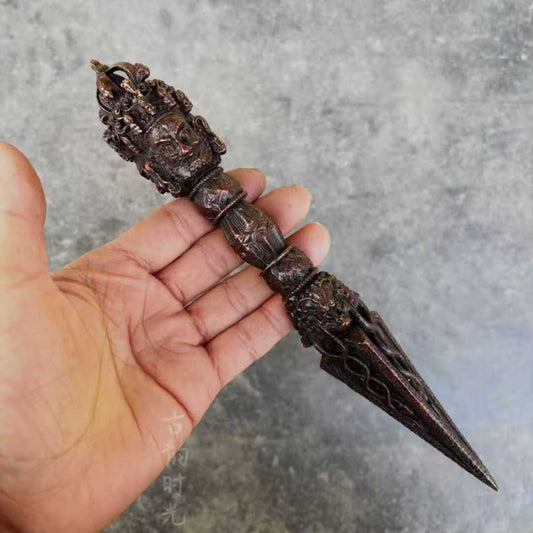 This Tibetan Three-Faced Phurba with Vajra is a hand-carved brass ritual tool, embodying spiritual protection and magical power. Ideal for Tibetan Buddhist ceremonies, meditation, and sacred spaces.
