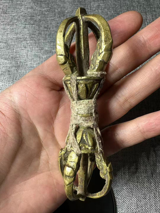A unique and traditional Tibetan brass Vajra with an aged patina finish. Ideal for use in Buddhist rituals, meditation spaces, and as a powerful spiritual tool or decorative piece.