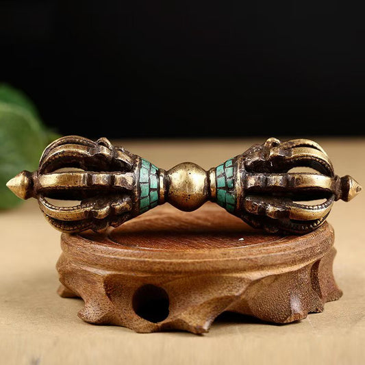 Handcrafted antique brass nine-pronged Vajra with turquoise inlay, inspired by Tibetan Buddhist ritual implements culture, showcasing traditional Buddhist ritual implements art.