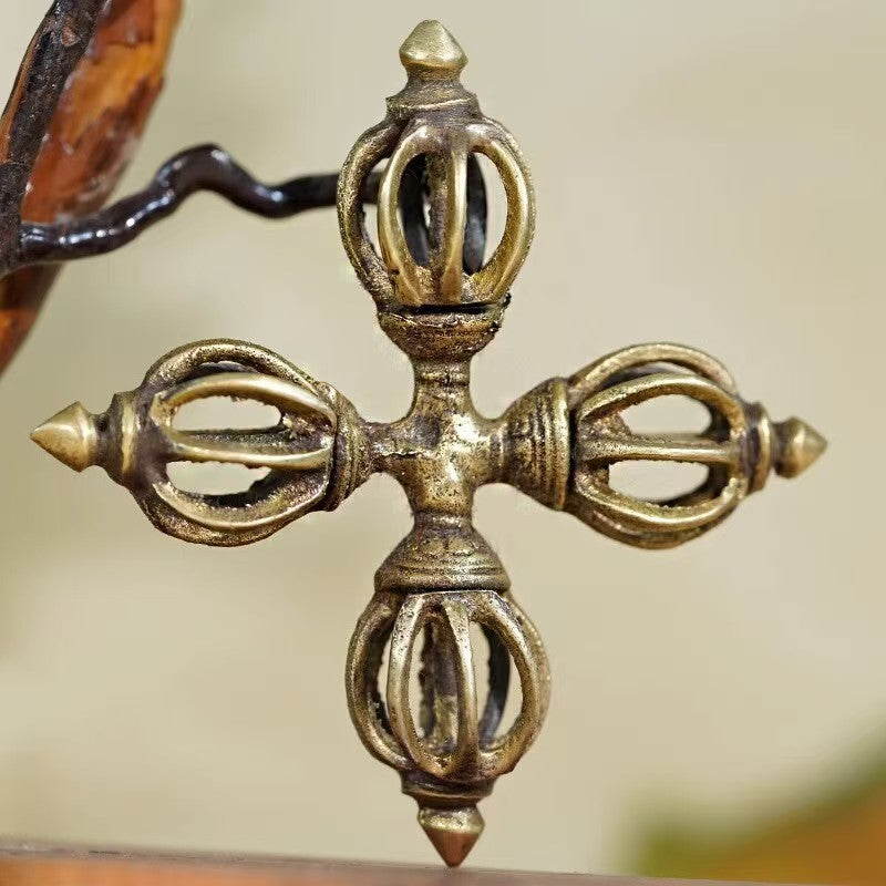 Handcrafted brass cross Vajra, inspired by Tibetan Buddhist ritual implements culture, showcasing traditional Buddhist ritual implements art with intricate details.