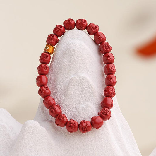  An artisan Tibetan Buddhist mala bracelet made from strung cinnabar beads, featuring a central Buddha charm. Represents handmade jewelry art traditionally valued for protection and mindfulness.