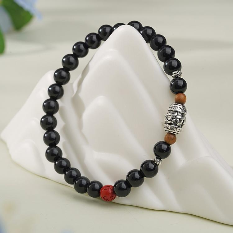 Black obsidian bead bracelet handcrafted in Tibetan Buddhist jewelry style, perfect for protection and spiritual practices. Jewelry art for peace.