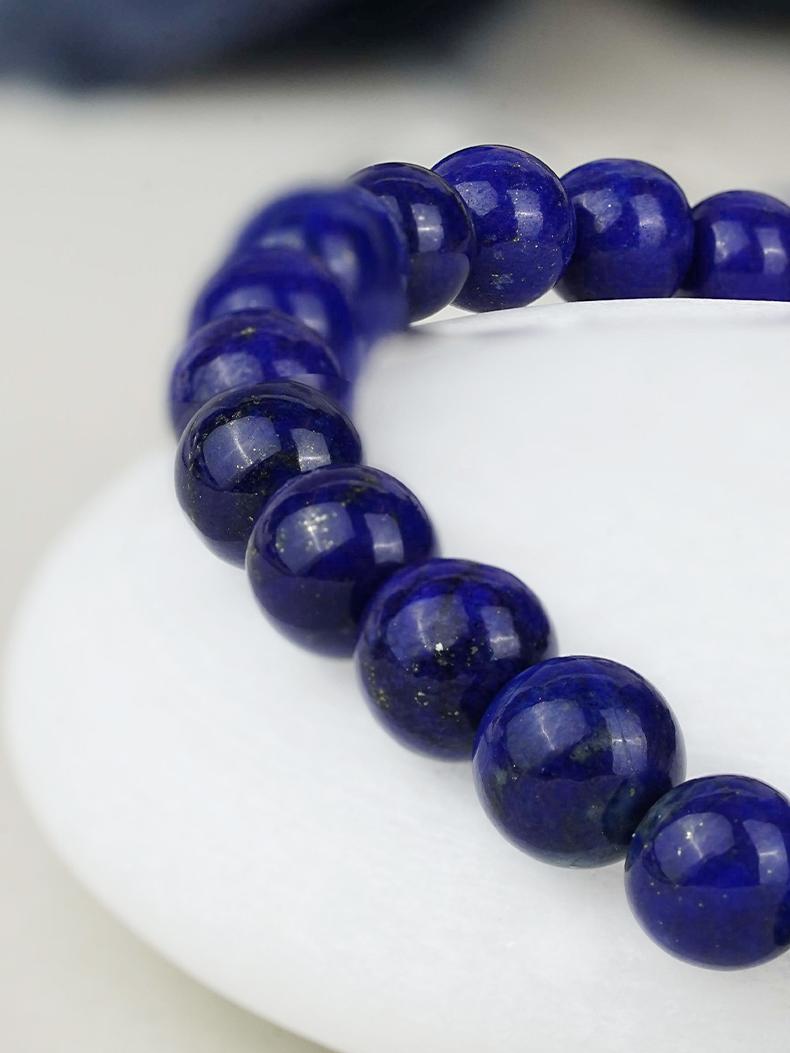 Handmade lapis and carved shell bead bracelet inspired by Tibetan Buddhist Jewelry Culture and created with detailed jewelry art design.