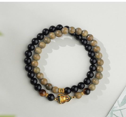 Handmade Tibetan Buddhist jewelry bracelet made with natural Obsidian and Green Sandalwood. A unique piece combining ancient Tibetan symbolism and modern craftsmanship, perfect for those seeking balance and protection