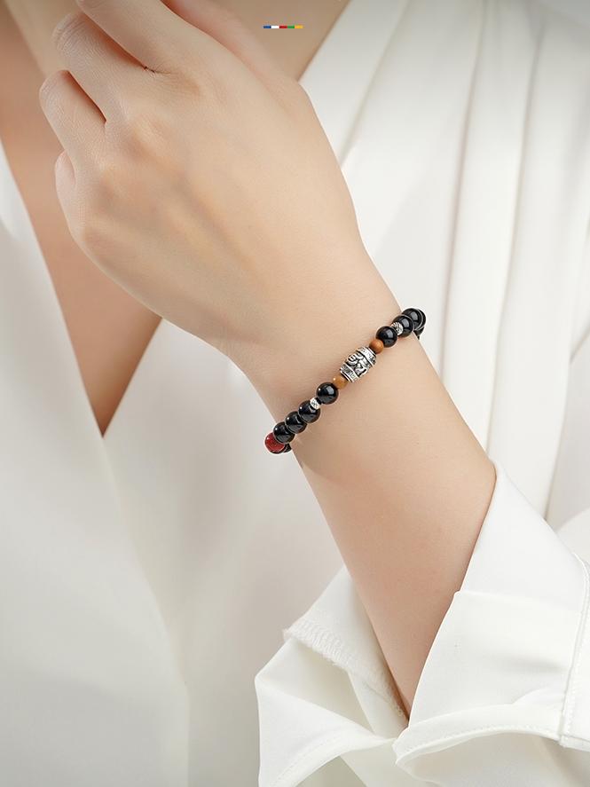 Tibetan Buddhist black obsidian bracelet featuring sacred symbols, handcrafted with care. A piece of jewelry art designed for spiritual growth.