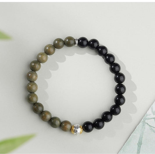 Handmade Tibetan Buddhist bracelet featuring Obsidian and Green Sandalwood beads. This artisan piece blends the powerful protective qualities of Obsidian with the calming energy of Green Sandalwood, perfect for meditation, yoga, and spiritual growth