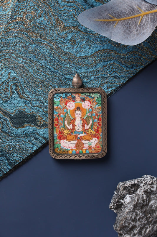 A 4x5cm hand-painted Four-Armed Avalokiteshvara (Chenrezig) Thangka in Menri style, encased in a silver Nine-Colored Deer frame.