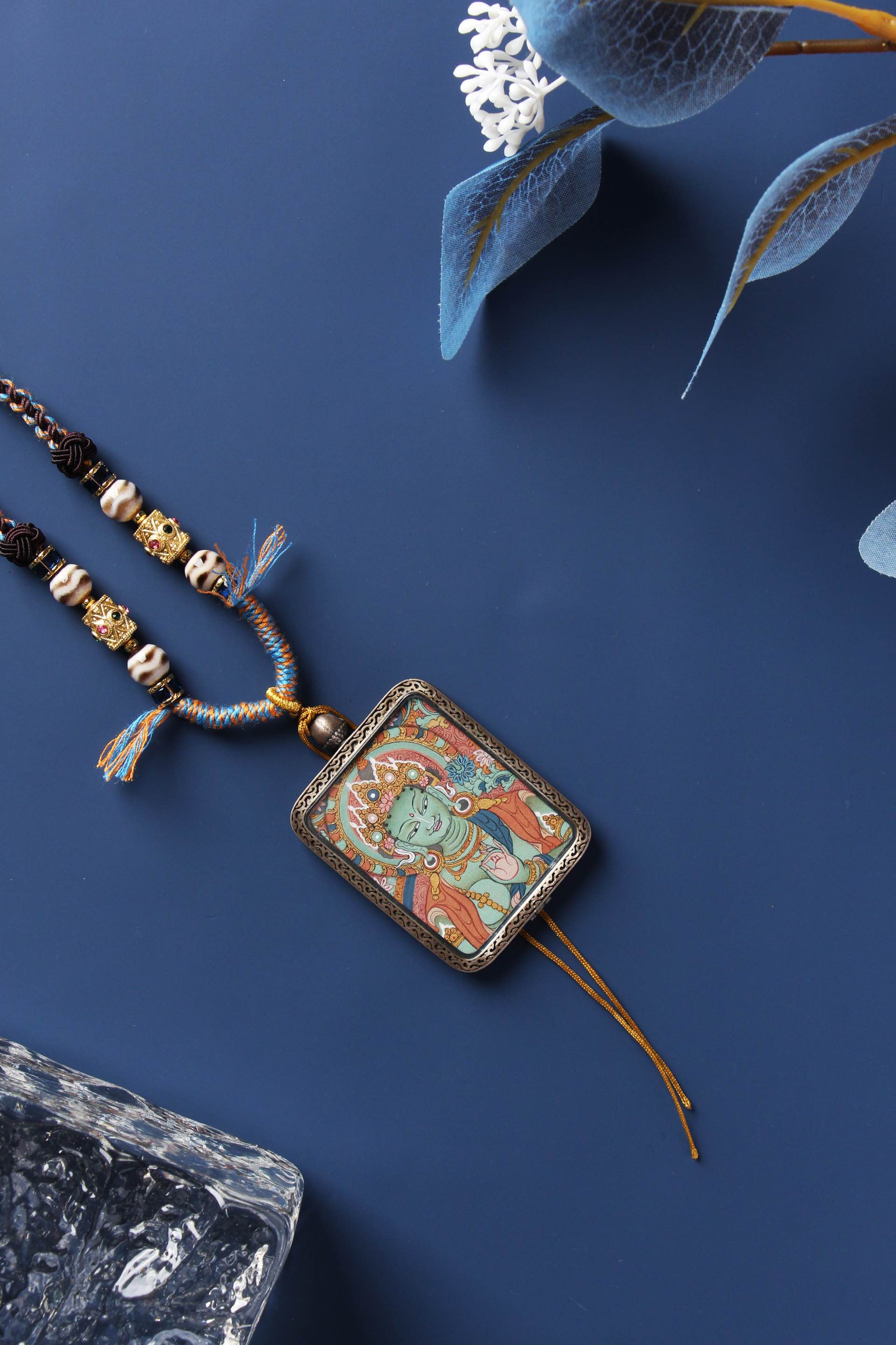 A 3.5x4.5cm hand-painted Green Tara Buddha Head Thangka in Tibetan Qi'gang style with a hand-woven spiritual necklace.