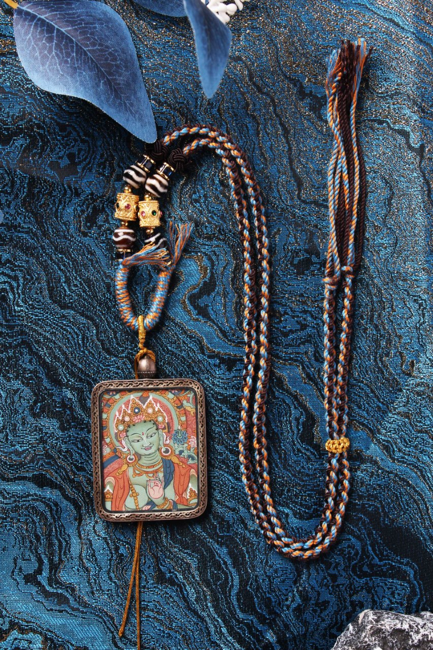 Detailed close-up of the Green Tara Buddha Head core, highlighting the serene expression and authentic Tibetan mineral pigment colors.
