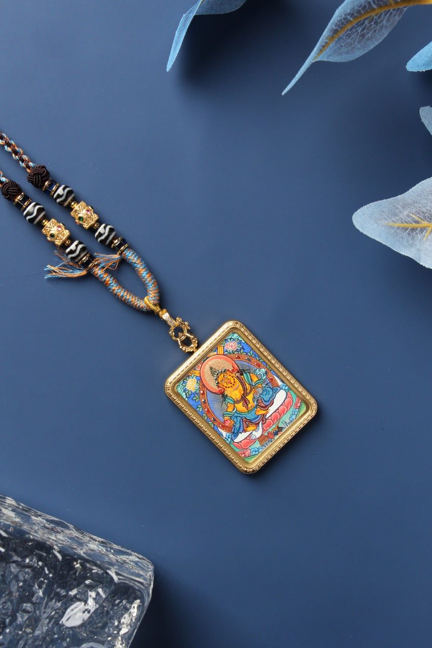 A 3.5x4.5cm hand-painted Rebgong Yellow Zambhala Thangka pendant, depicting the King of Wealth with a treasure-spouting mongoose in mineral pigments.