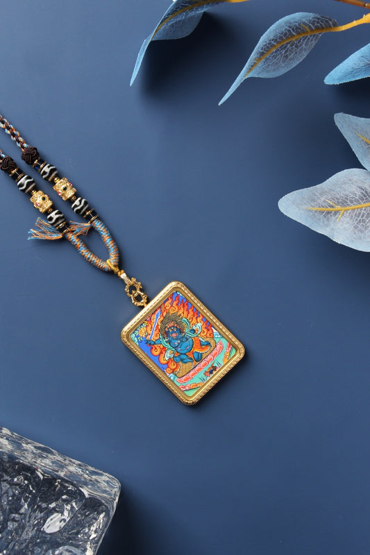 A 3.5x4.5cm Rebgong Acala (Budong Mingwang) Thangka pendant hand-painted with mineral pigments, showing the wrathful guardian with a flaming sword.