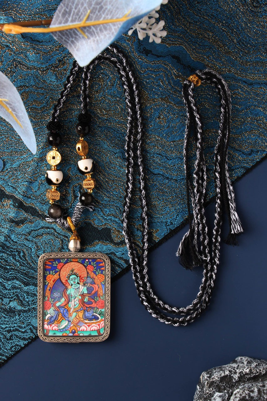 Close-up of the Green Tara Thangka painting core, highlighting the intricate gold lines and the youthful, emerald-hued complexion of the deity.