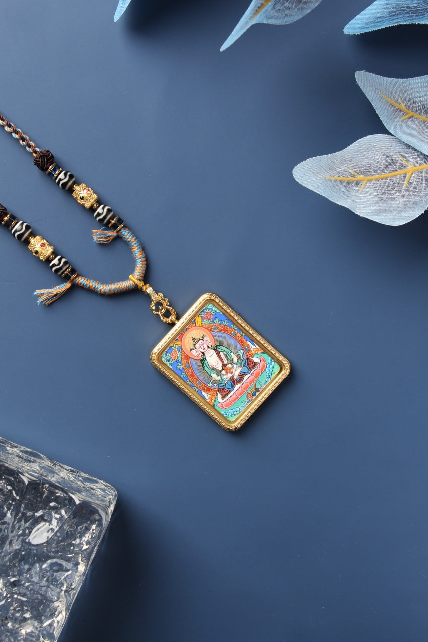 Close-up of a Rebgong Manjushri Thangka pendant showcasing the intricate gold powder linework by Lama masters.