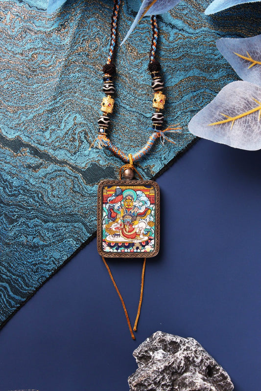A collection of hand-painted Tibetan deity pendants from Rebgong, including Vaishravana and other guardian figures.