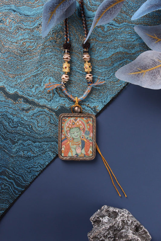A collection of Qi'gang style Tibetan Thangkas including Manjushri and Green Tara Buddha Head pendants.