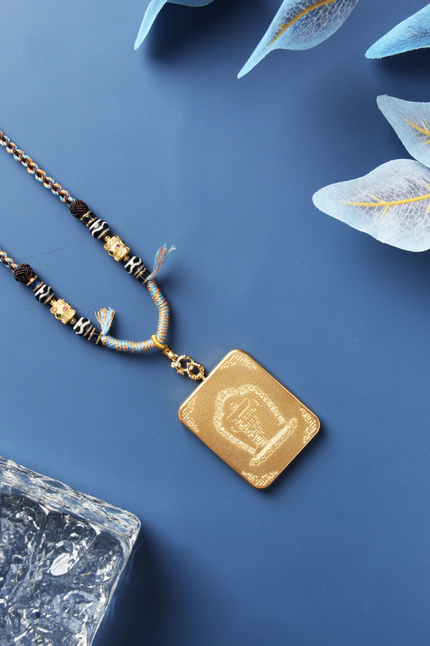 A Four-Armed Avalokiteshvara Thangka pendant from Rebgong displayed with a traditional hand-woven beaded cord.