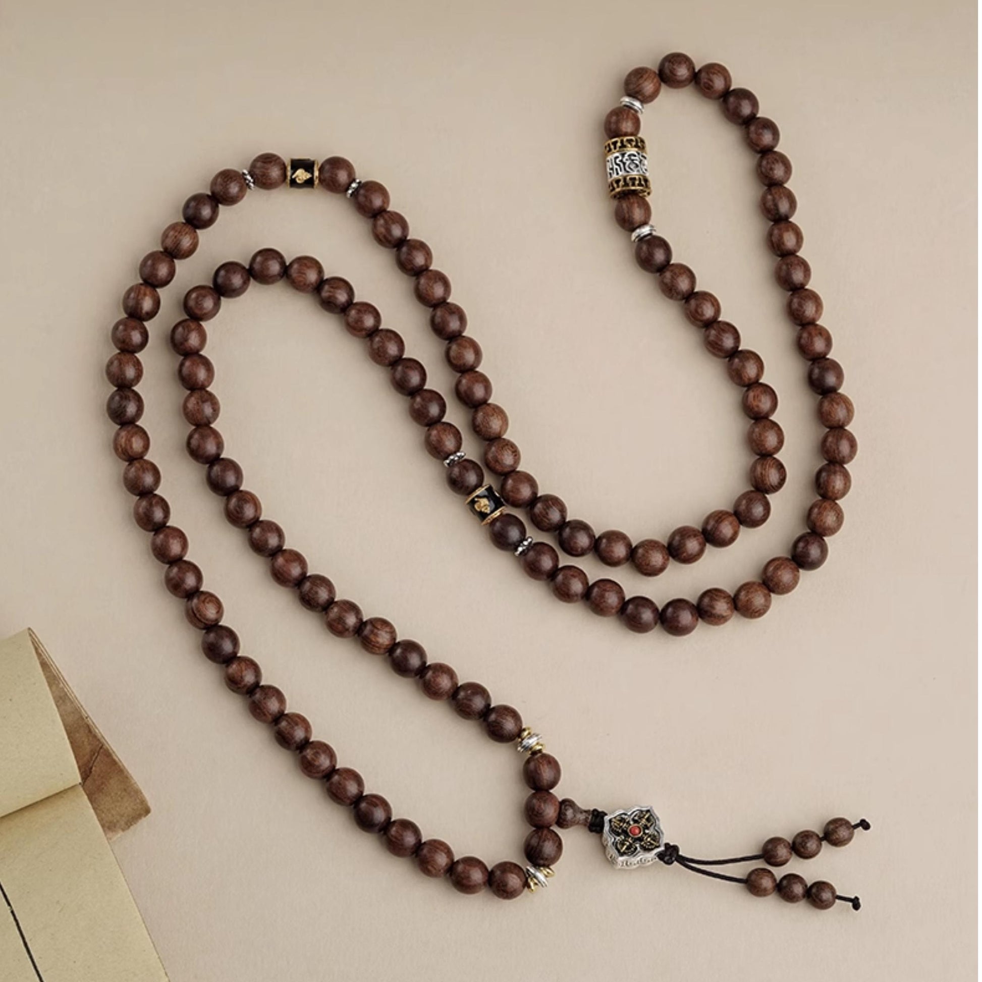 Tibetan Buddhist sandalwood 108-bead mala crafted with copper mantra accessories for meditation.