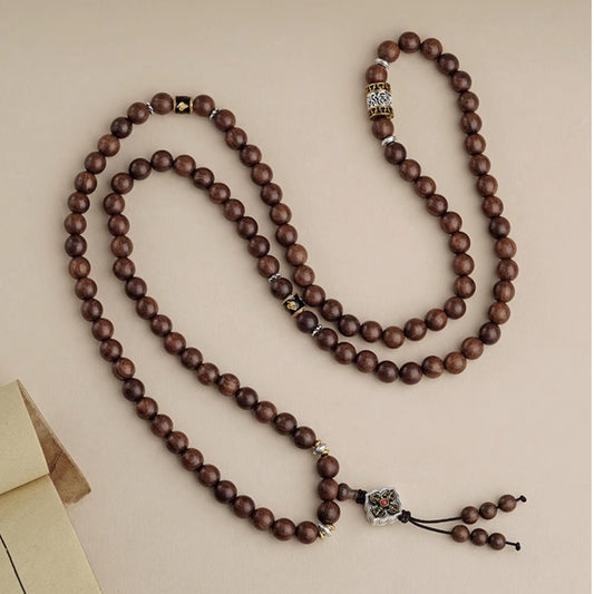 Tibetan Buddhist sandalwood 108-bead mala crafted with copper mantra accessories for meditation.