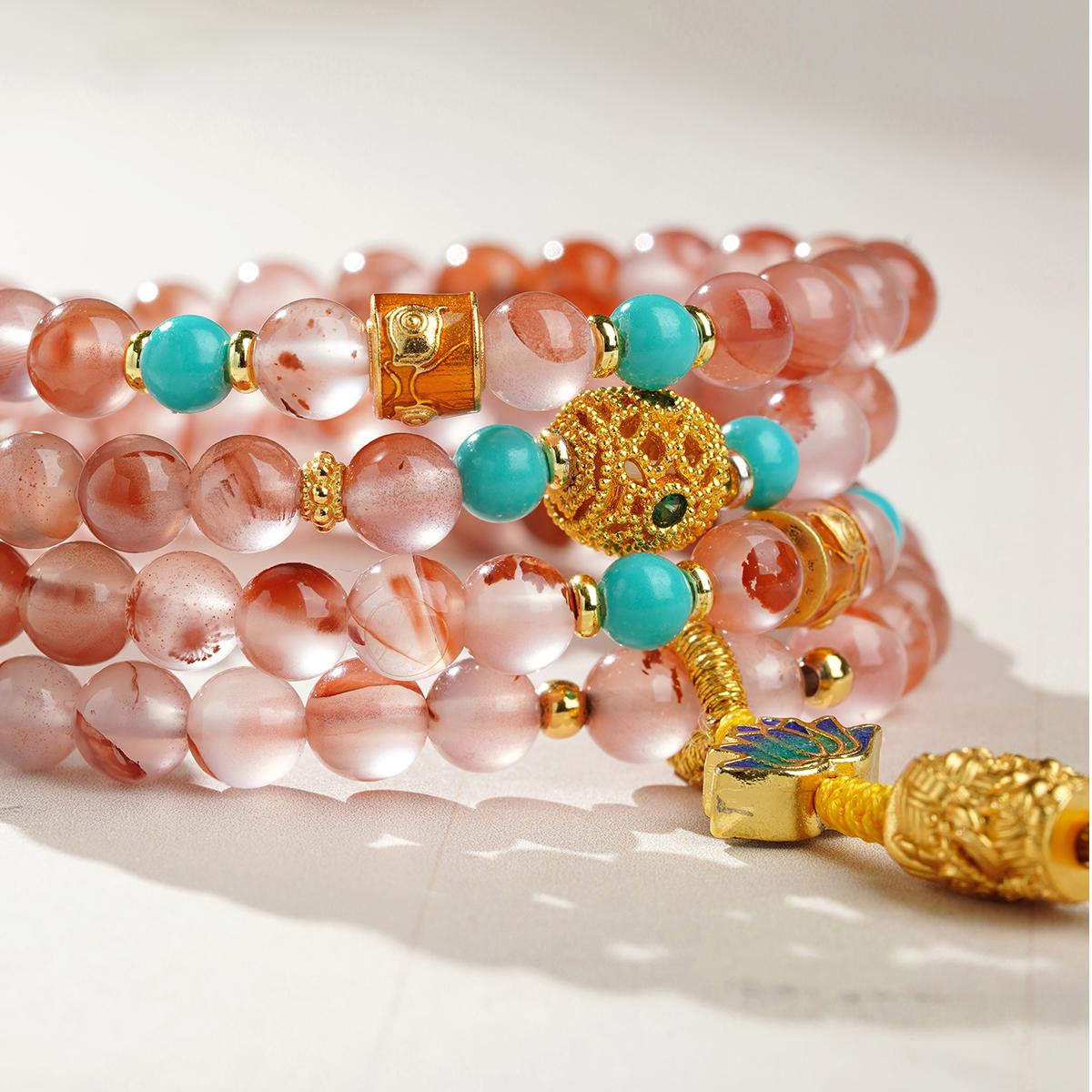 Handcrafted Tibetan Buddhist red agate mala featuring copper carved pendant and glass beads.