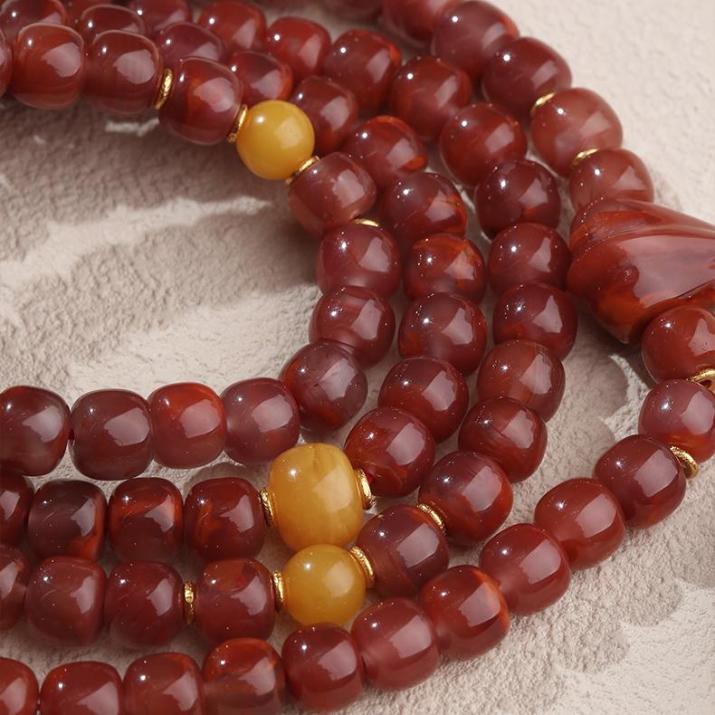 Tibetan Buddhist 108-bead mala made of South Red Agate, honey amber, and silver for blessings and protection.