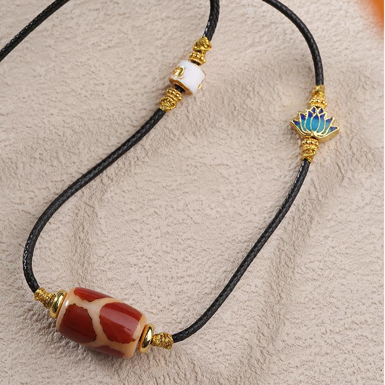 Red agate Qihongrou Tianzu pendant with copper lotus, a symbol of wisdom and purity in Tibetan Buddhism.