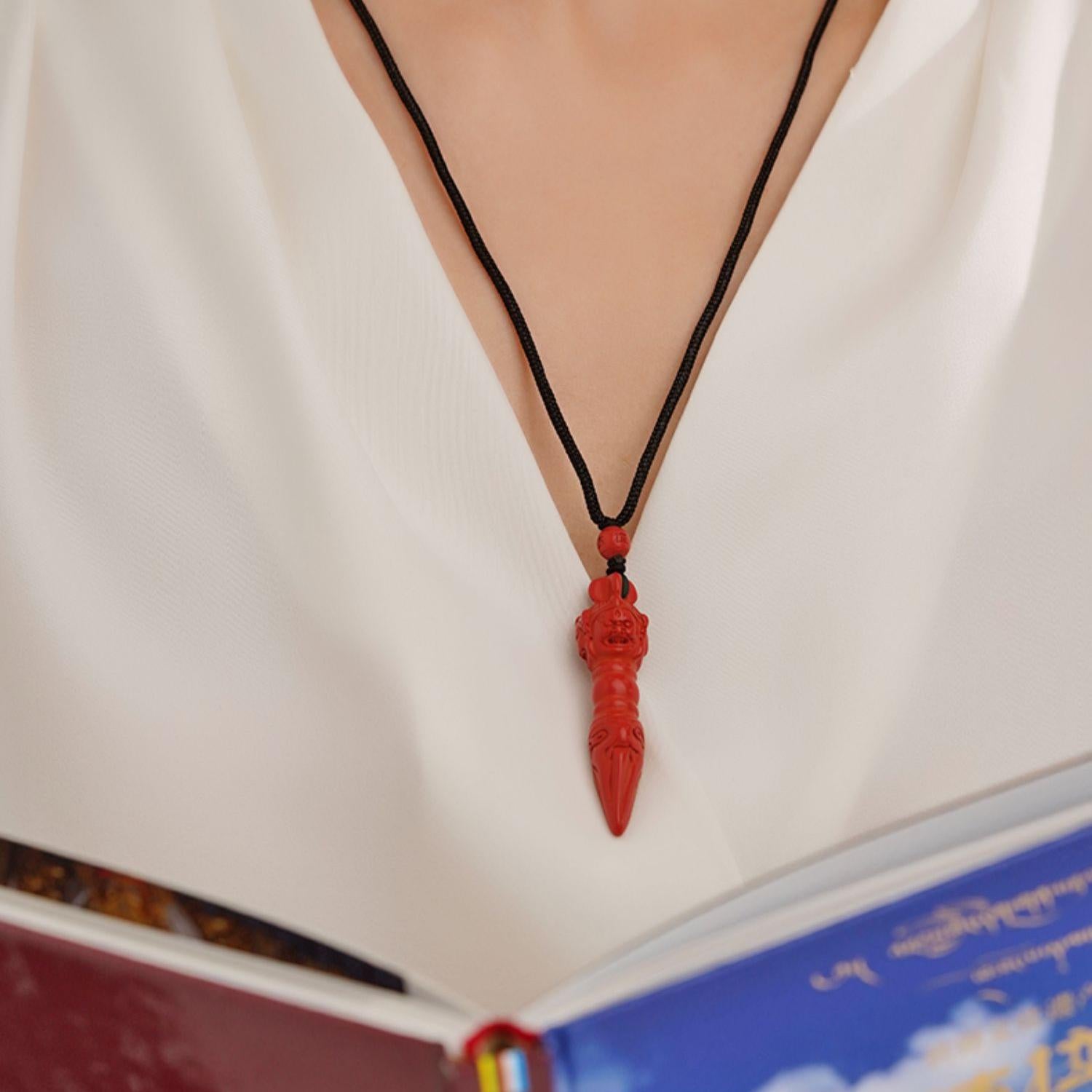Elegant Qitianle cinnabar pendant on adjustable cord, Tibetan Buddhist design.