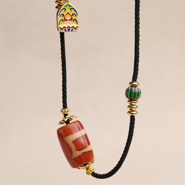 Single Eye Dzi bead pendant made from genuine red agate and detailed blue glass in Tibetan style.