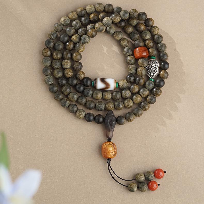 Tibetan Buddhist prayer beads crafted from agarwood, cow bone, and agate for protection and serenity.