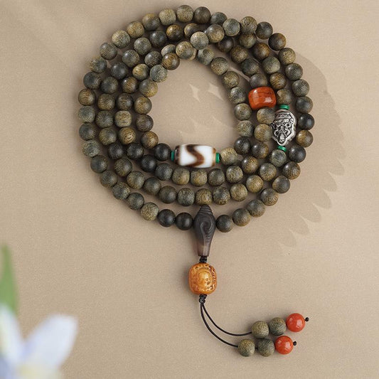 Tibetan Buddhist prayer beads crafted from agarwood, cow bone, and agate for protection and serenity.