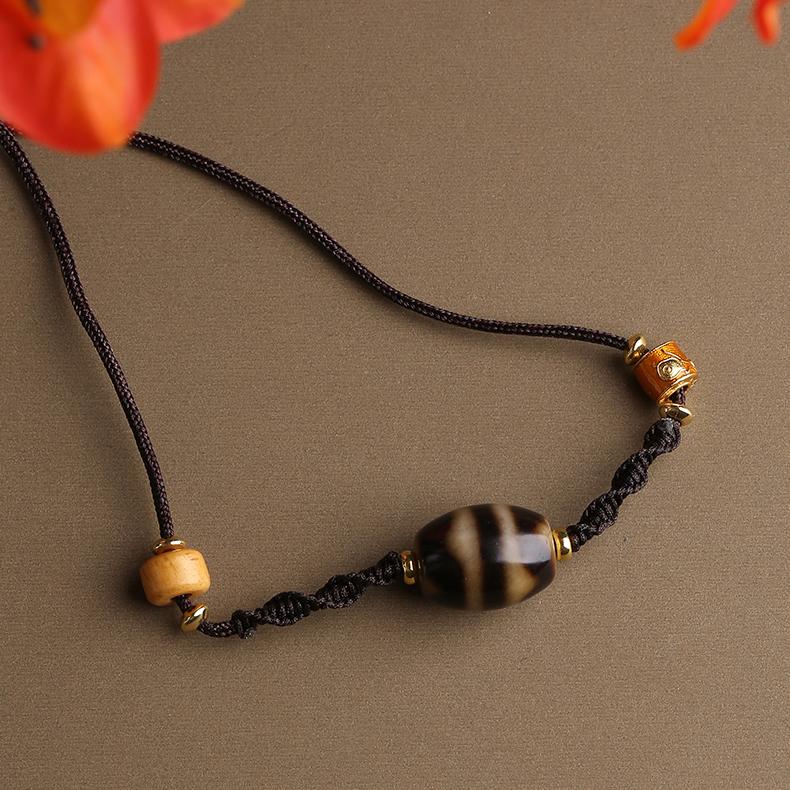 Tibetan Buddhist agate Dzi tiger tooth pendant with natural bone, handcrafted jewelry art.