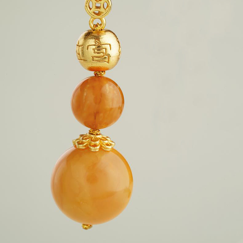 "Golden wind-dew amber earrings with 925 silver, featuring the beauty of Tibetan Buddhist craftsmanship and energy."