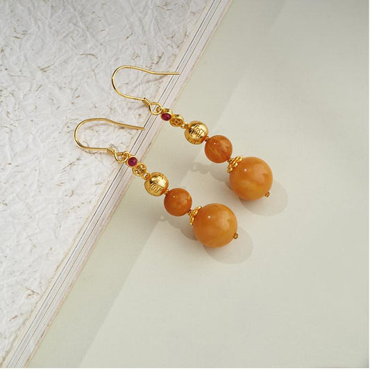 "Handmade Tibetan Buddhist golden wind-dew amber earrings with 925 silver and cubic zirconia."