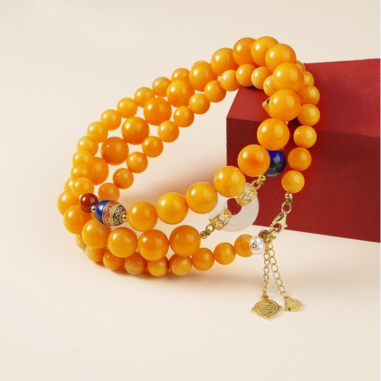 Amber and jade Buddhist necklace with lapis lazuli and pearls, handcrafted for balance and inner beauty.